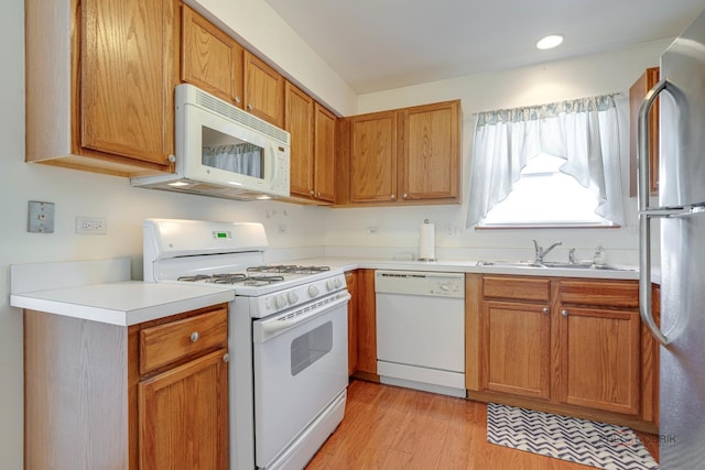 kitchen with sink, white appliances, and light wood-type flooring