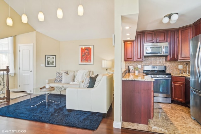 kitchen with light stone counters, appliances with stainless steel finishes, decorative light fixtures, and backsplash