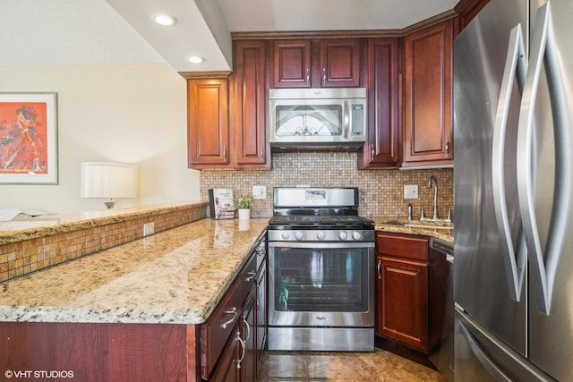 kitchen featuring sink, tasteful backsplash, appliances with stainless steel finishes, kitchen peninsula, and light stone countertops