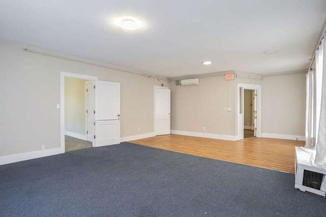 carpeted spare room with ornamental molding and a wall unit AC