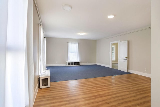 spare room featuring wood-type flooring and heating unit