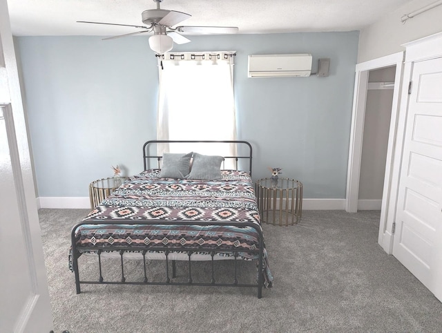 carpeted bedroom with ceiling fan and a wall mounted AC