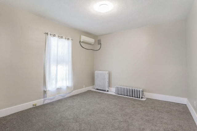 spare room featuring a wall mounted air conditioner, carpet flooring, and radiator