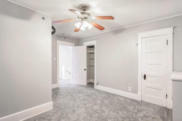 carpeted spare room featuring ceiling fan and ornamental molding