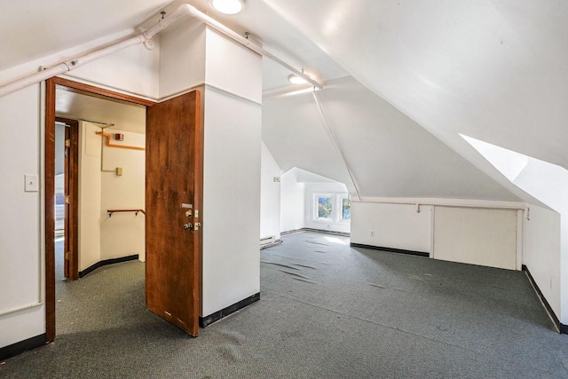 bonus room featuring lofted ceiling and dark carpet