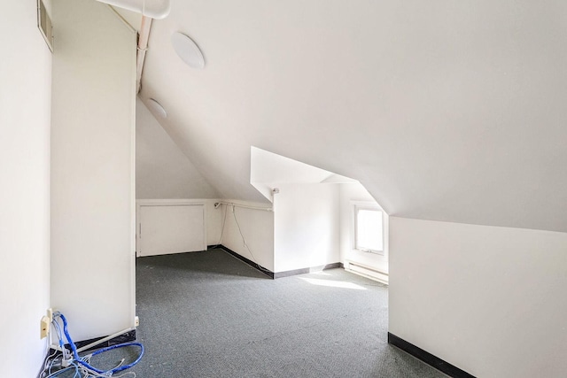 bonus room featuring lofted ceiling and dark colored carpet