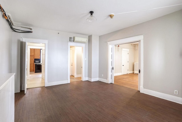 unfurnished bedroom with dark wood-type flooring and a wall mounted AC