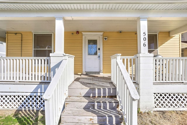 view of exterior entry featuring covered porch