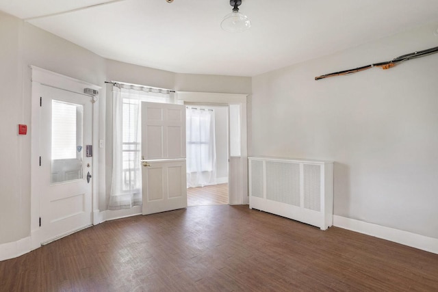 entrance foyer with radiator heating unit and dark hardwood / wood-style flooring