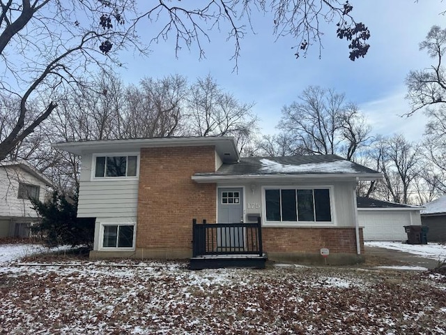 snow covered house featuring a garage