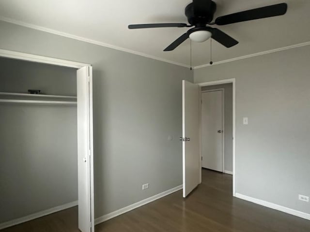 unfurnished bedroom featuring ornamental molding, dark wood-type flooring, ceiling fan, and a closet