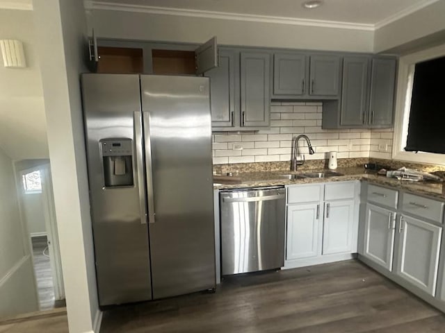 kitchen featuring tasteful backsplash, sink, dark stone counters, stainless steel appliances, and dark wood-type flooring