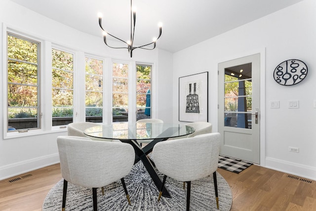 dining area featuring an inviting chandelier and light hardwood / wood-style flooring