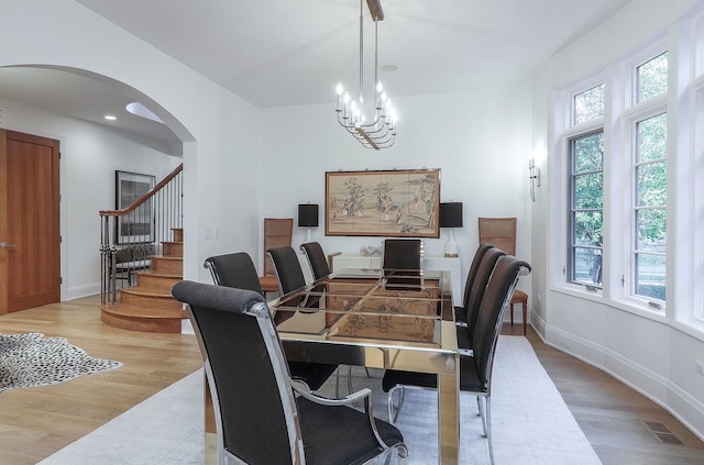 dining area with a notable chandelier and light hardwood / wood-style flooring