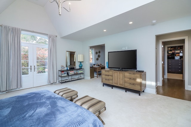 bedroom with carpet, a notable chandelier, high vaulted ceiling, and french doors