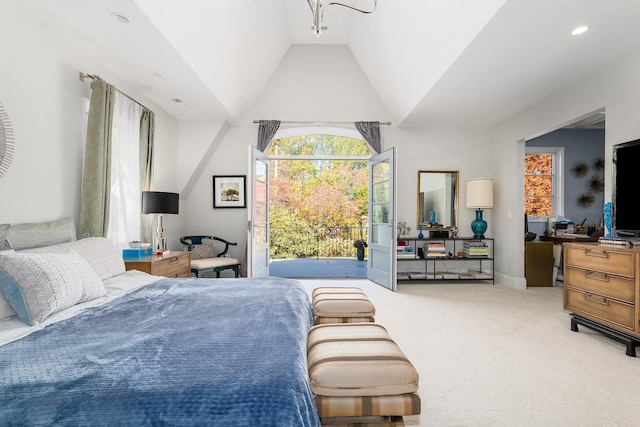 carpeted bedroom with vaulted ceiling and access to exterior