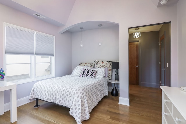 bedroom with lofted ceiling and dark hardwood / wood-style floors