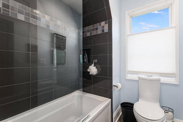 bathroom with tiled shower / bath and toilet