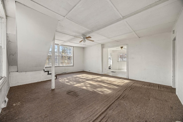 unfurnished room featuring ceiling fan and dark carpet