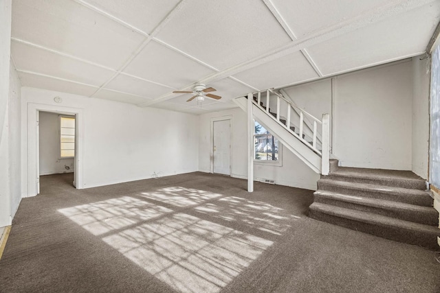 basement with ceiling fan and dark colored carpet