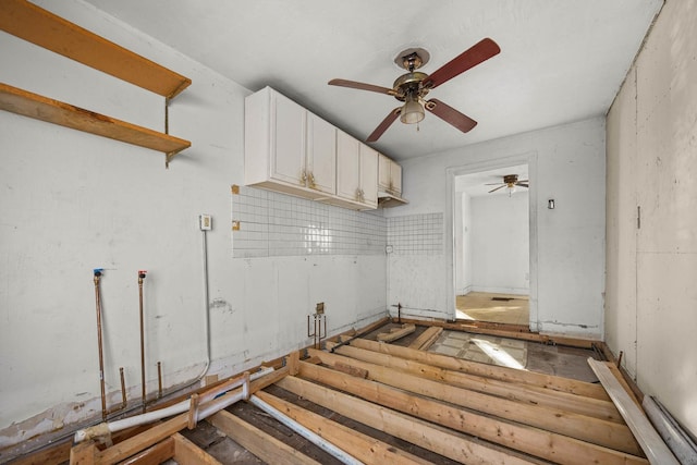 interior space featuring ceiling fan and white cabinetry