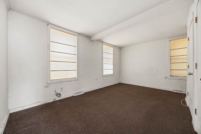 unfurnished room with dark colored carpet and beam ceiling