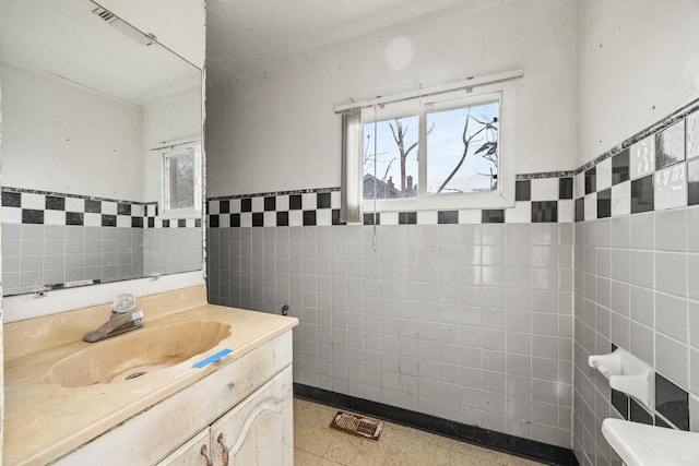 bathroom with tile walls, vanity, and ornamental molding