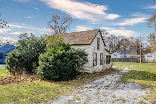 view of side of home with a yard