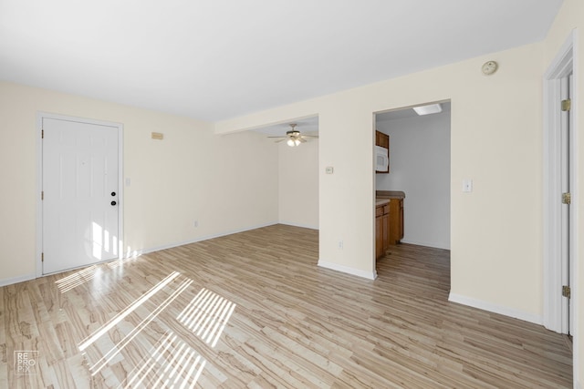 unfurnished living room with light hardwood / wood-style floors, beam ceiling, and ceiling fan