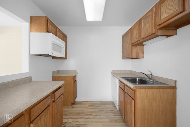 kitchen with sink, white appliances, and light wood-type flooring