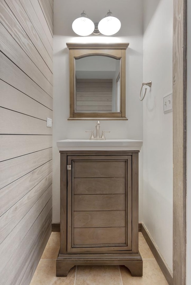 bathroom featuring tile patterned floors, vanity, and wooden walls