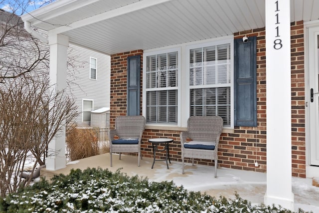 snow covered patio featuring a porch