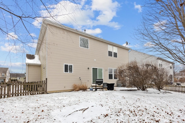 view of snow covered back of property