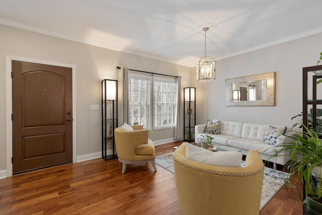 living room with dark hardwood / wood-style flooring, ornamental molding, and an inviting chandelier