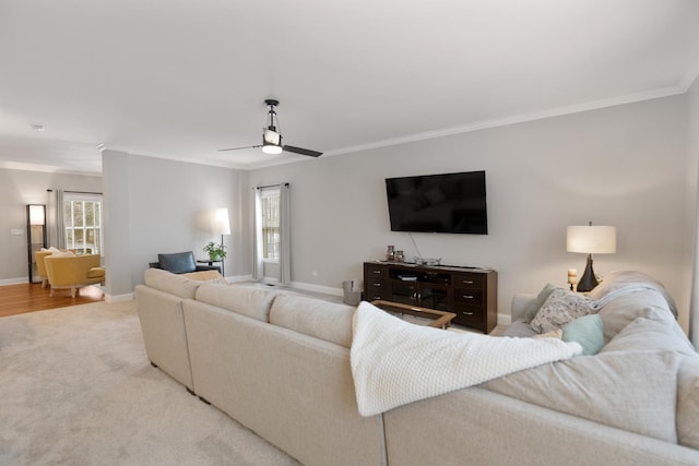 living room featuring crown molding, ceiling fan, and light colored carpet