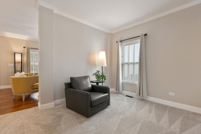 living area featuring crown molding and light colored carpet