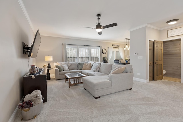 carpeted living room featuring ornamental molding and ceiling fan with notable chandelier