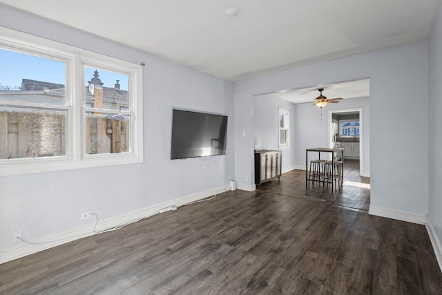 unfurnished living room with dark wood-type flooring and ceiling fan