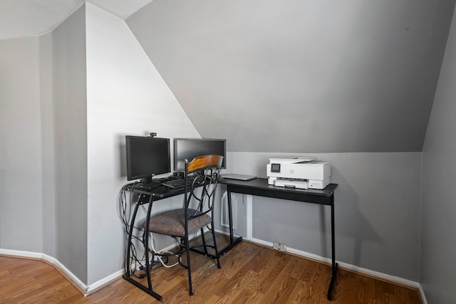 home office with vaulted ceiling and hardwood / wood-style floors