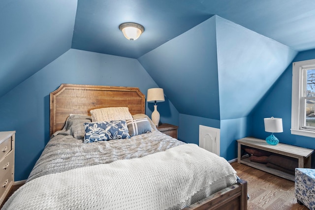 bedroom featuring lofted ceiling and light hardwood / wood-style flooring