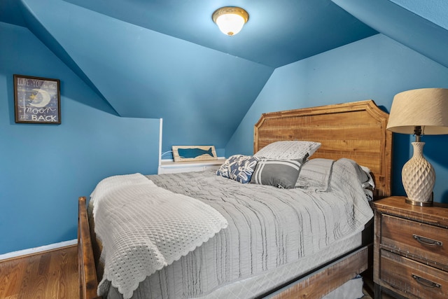 bedroom featuring hardwood / wood-style flooring and lofted ceiling