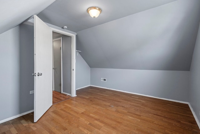 additional living space featuring lofted ceiling and light hardwood / wood-style floors