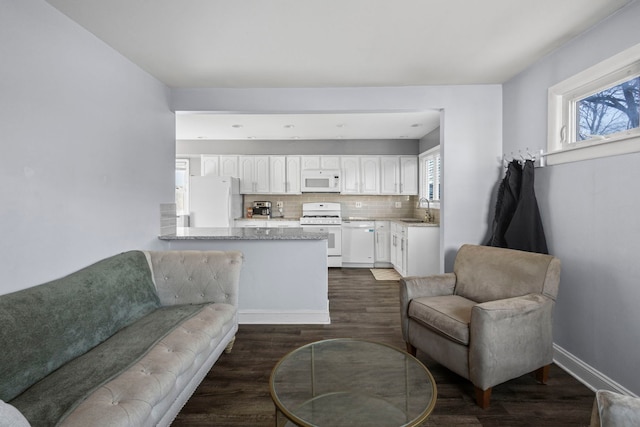 living room with a wealth of natural light, sink, and dark wood-type flooring