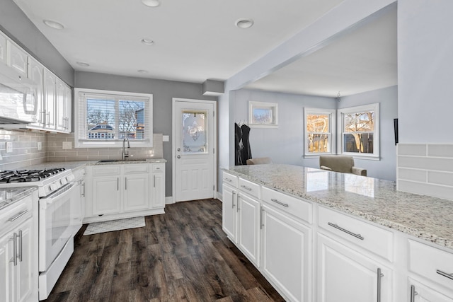 kitchen with dark hardwood / wood-style floors, white cabinetry, sink, backsplash, and white appliances