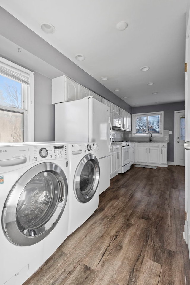 laundry area with sink, dark hardwood / wood-style flooring, and washing machine and dryer