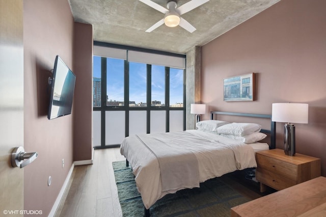 bedroom featuring ceiling fan, hardwood / wood-style floors, and floor to ceiling windows