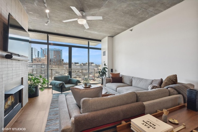 living room with floor to ceiling windows, hardwood / wood-style flooring, and ceiling fan