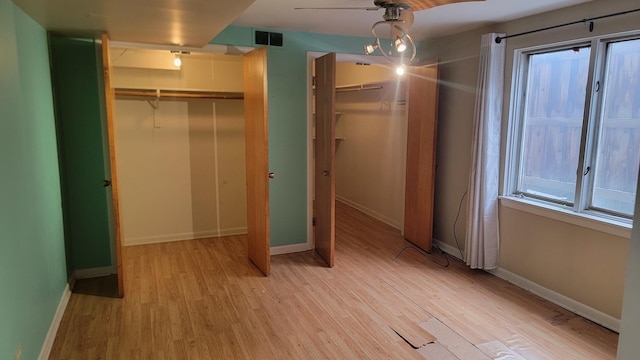 unfurnished bedroom with multiple windows and light hardwood / wood-style flooring