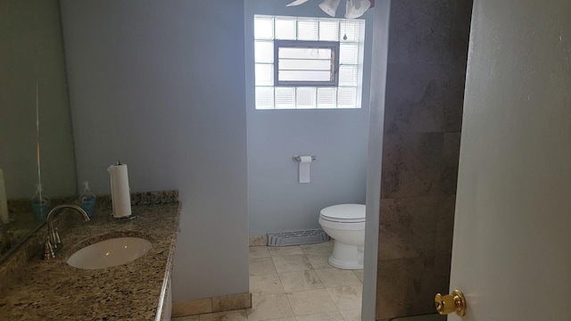 bathroom with ceiling fan, vanity, toilet, and tile patterned flooring