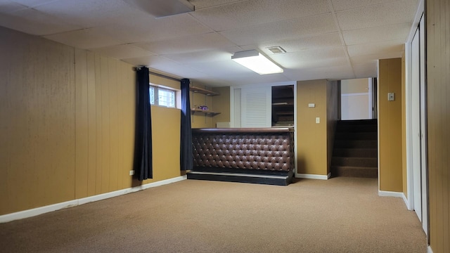 basement featuring light carpet and a drop ceiling